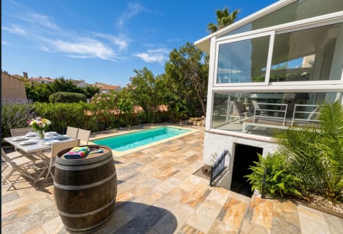 Terrasse ensoleillée avec piscine turquoise à la villa Chez Mara à Canet-en-Roussillon, table de repas et décor moderne