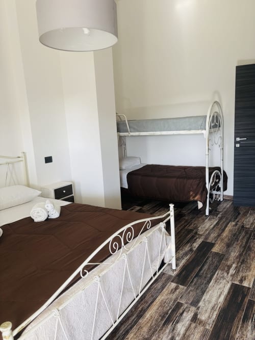 Spaziosa camera quadrupla al B&B Hélios di Nardò con due letti in ferro battuto e servizi moderni