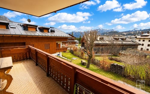 Wooden balcony with mountain views at Ciasa Ca Guargné, Cortina d'Ampezzo apartment with snow-capped peaks and alpine village