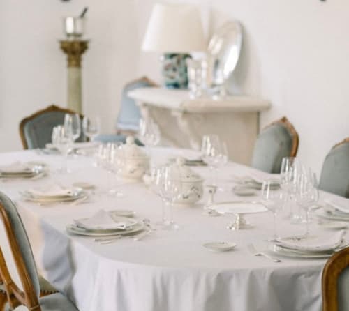 Élégante salle à manger du Domaine du Fortin à Ménerbes avec table dressée, nappes blanches et décor français classique