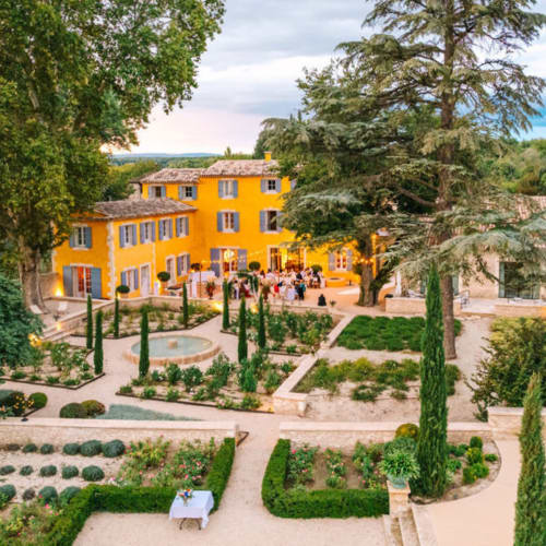 Villa française jaune éclatant avec jardins entretenus et cyprès au Domaine du Fortin à Ménerbes