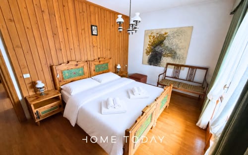 Bright bedroom at Hometoday Cortina d'Ampezzo with wooden bed, white linens, mountain view, and traditional Alpine decor