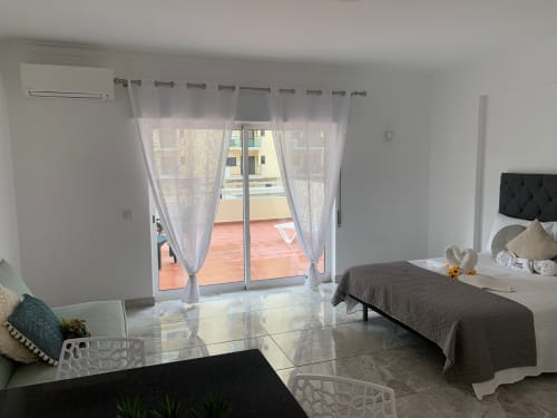 Quarto moderno no apartamento Sweet Home Casa dos Arcos, Portimão, com cama, acesso à varanda, vista da cidade e design contemporâneo