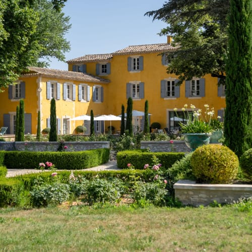 Le Domaine du Fortin yellow manor house with manicured gardens in Ménerbes, France