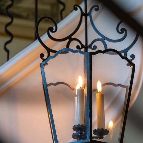 Ornate wrought iron lantern with lit candles at Le Domaine du Fortin, a hotel in Ménerbes, France