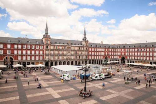 Plaza Mayor Madrid with red historic buildings and arcaded courtyard, cityscape view from Charming View apartment