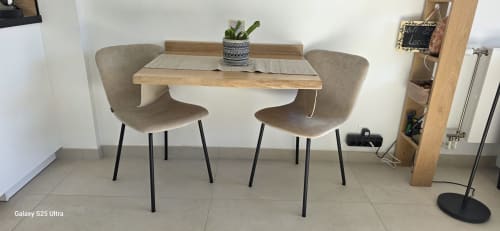 Coin repas du studio Zoppas Aix Les Bains avec table en bois et deux chaises taupe dans Le Nid du 9