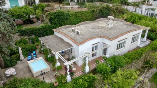Vista aerea della villa esclusiva La Capperina a Capri con esterno bianco, tetto in terracotta, piscina e vegetazione rigogliosa