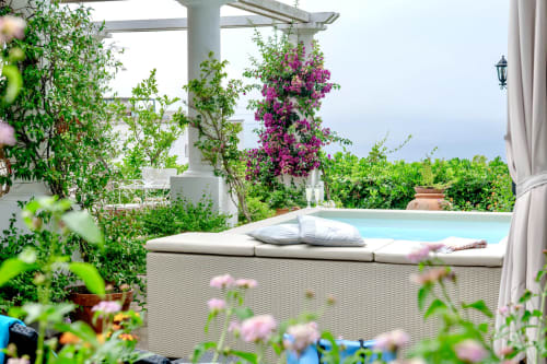 Terrazza della lussuosa villa a Capri con piscina riscaldata, bouganvillea fiorita, vista mare e zona relax