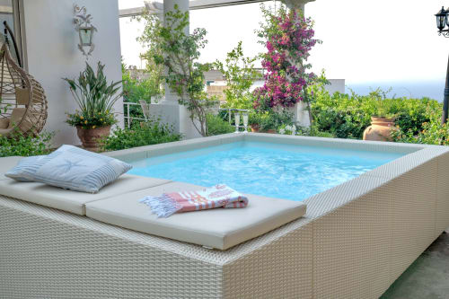 Terrazza esclusiva a bordo piscina della villa La Capperina a Capri con piscina blu, vista mare e piante fiorite