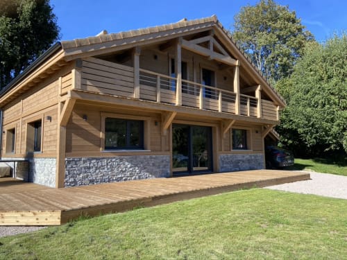 Villa en bois moderne avec base en pierre, terrasse en bois et vue sur les montagnes au Chalet les Roitelets à Gérardmer