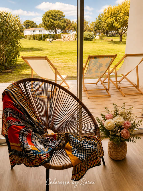 Entspannungsbereich auf der Terrasse von Calarossa by Sarai in Lecci mit Flechtsessel, Liegen und malerischem Gartenblick