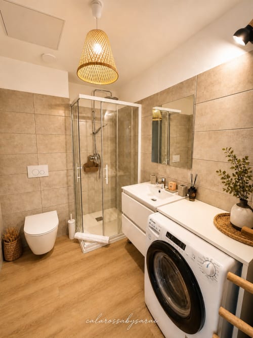 Modern bathroom at Calarossa By Sarai in Lecci with shower, double sink, washing machine, and wooden flooring