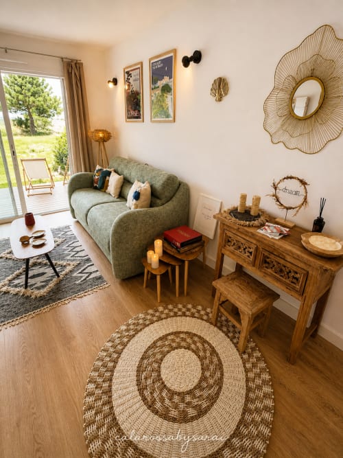 Cozy Calarossa By Sarai apartment in Lecci with green sofa, wooden furniture, garden view, and coastal decor