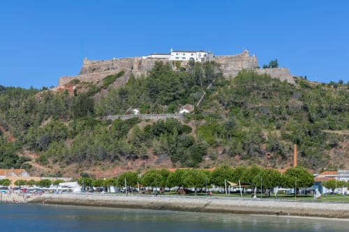 Fortaleza de Casa Redonda Aroeira no topo da colina com vista para praia e rio em Portugal
