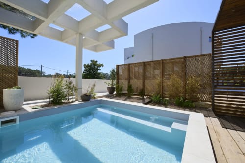 Piscina moderna da Casa Redonda Aroeira com pérgola branca e painéis de madeira, Aroeira Portugal