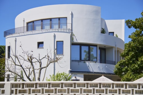 Arquitetura circular branca marcante de Casa Redonda Aroeira com varanda curva com vista para a costa portuguesa