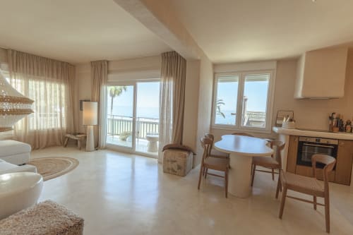 Spacious luxury hotel suite with ocean views, modern furnishings, dining area, and coastal balcony in Spain