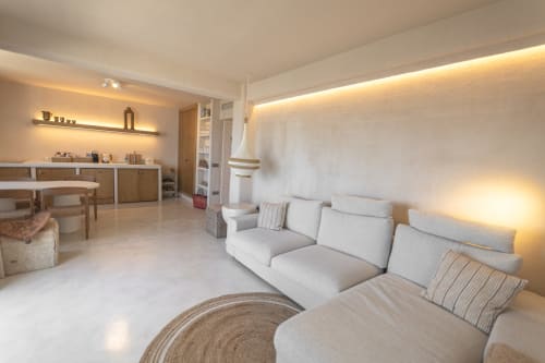Modern hotel suite with beige sofa, ambient lighting, wooden furniture, and minimalist décor at Escanda Building Solutions,