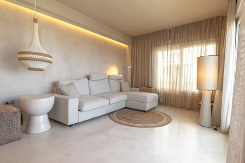 Modern luxury hotel suite at Escanda Building Solutions with beige sectional sofa, pendant lighting, and coastal design