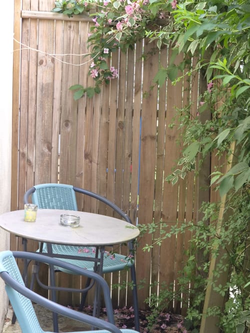 Terrasse avec salon extérieur du studio à Orval Et Sens à Orvault : table, chaises et fleurs grimpantes sur bois