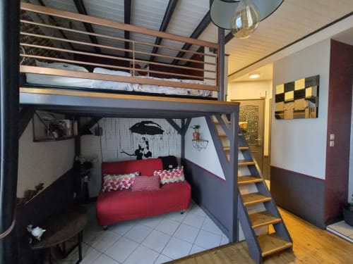 Studio loft Orval Et Sens avec mezzanine, canapé rouge, escalier bois et équipements modernes à Orvault