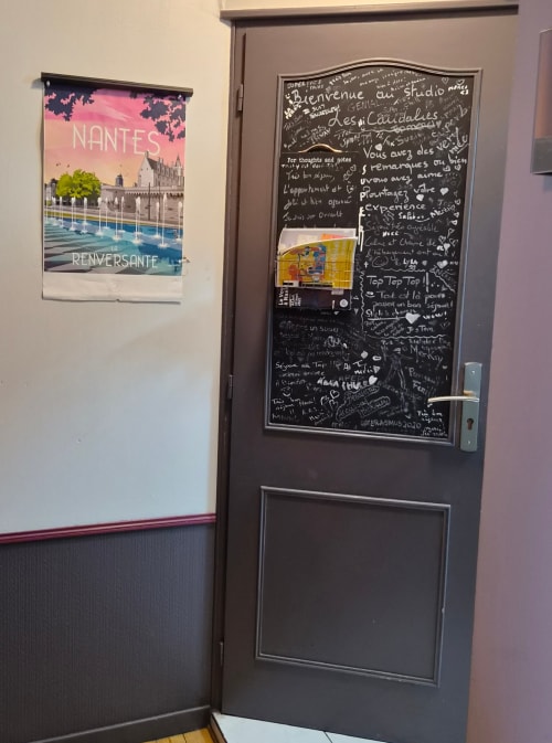 Porte avec tableau de bienvenue et affiche Nantes à l'hôtel Orval Et Sens, studio à Orvault