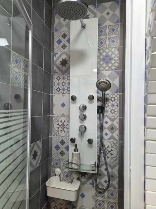 Douche moderne avec pomme de pluie et buses de massages à l'hôtel Orval Et Sens à Orvault, décorée de bleu et