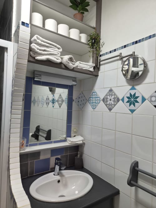 Salle de bain moderne du Studio Les Caudalies à l'hôtel Orval Et Sens, Orvault, avec carrelage blanc et motifs bleus décoratifsBlue