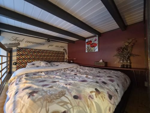 Chambre douillette à l'hôtel Orval Et Sens à Orvault avec murs bordeaux, tête de lit motifs et puits de lumière