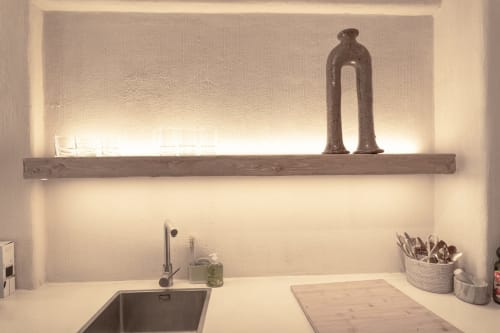 Modern hotel sink area with wooden shelf, decorative lamp, and organized workspace at Escanda Building Solutions