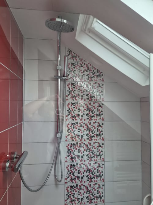Salle de bains moderne avec douche effet pluie et mur de carrelage décoratif rouge/noir - Appartement Orval Et Sens