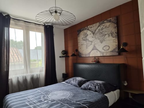 Chambre moderne à Orval Et Sens, Orvault avec mur d'accent marron, œuvre d'art cartographique, tête de lit sombre et vue sur la ville