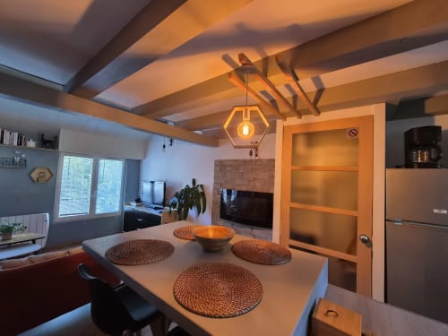 Élégante salle à manger de l'appartement L'Absolu chez Orval Et Sens, Orvault avec poutres en bois et luminaires suspendus