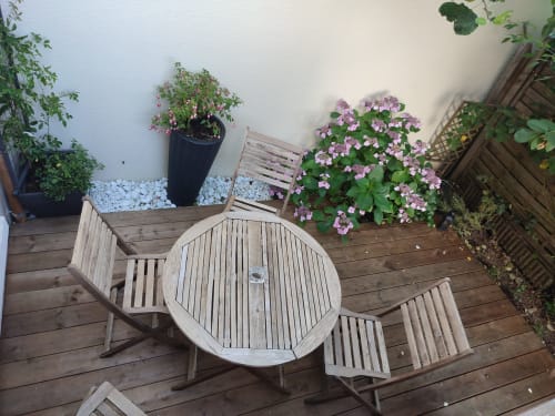 Mobilier de patio en bois et plantes fleuries roses sur la terrasse de l'appartement Orval Et Sens à Orvault