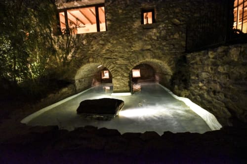 Historic stone courtyard with illuminated arches, thermal pool, and rustic architecture at Spanish hotel