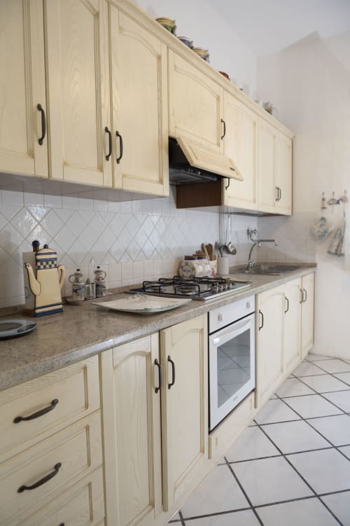 Cucina color crema con fornello a gas e rivestimento in piastrelle bianche all'hotel La Capperina di Capri, Italia