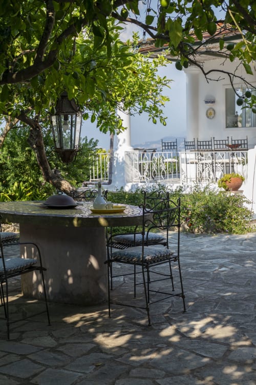 La terrazza all'ombra di La Capperina a Capri con sedute in ferro battuto e vista sul Mediterraneo