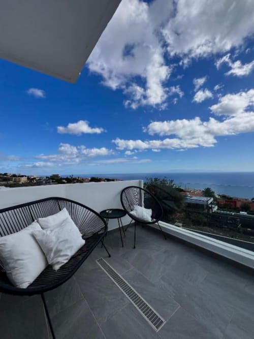 Terraza con vista al océano en Canary Treasure con tumbona negra, cojines blancos y vistas al mar en San Cristóbal de La Laguna