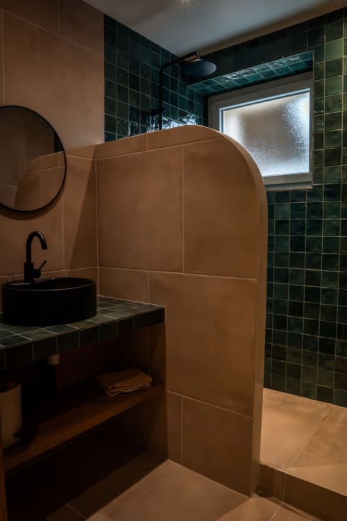 Salle de bain moderne à la Maison Antea au Puy-en-Velay avec carrelage en terre cuite, mur d'accent vert foncé, vasque ronde et
