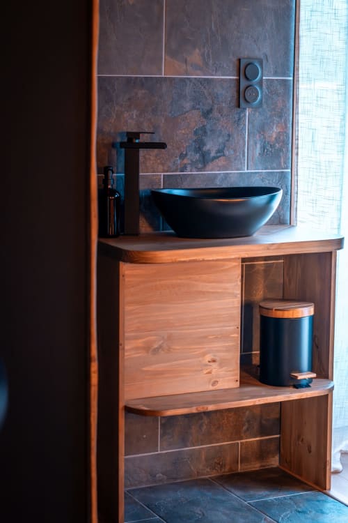 Lavabo moderne à Maison Antea Le Puy-en-Velay avec vasque noire, meuble en bois et mur en carrelage rustique