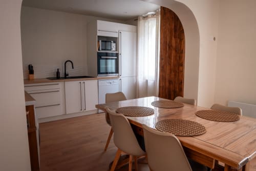 Salle à manger et cuisine cottage modernes à la Maison Antea B&B au Puy-en-Velay, avec table en bois et mobilier blanc