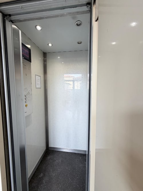 Modern elevator interior at Versilia Panoramic Luxury hotel in Como, Italy with polished walls and recessed lighting