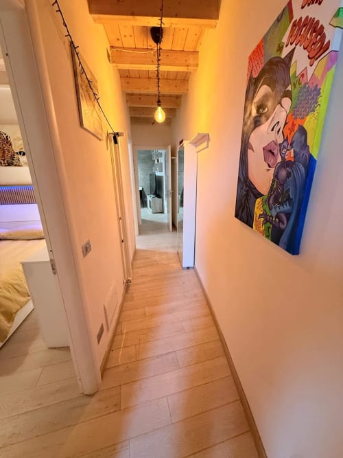 Modern hallway at Versilia Panoramic Luxury in Como with wooden floors, ambient lighting, and contemporary wall art