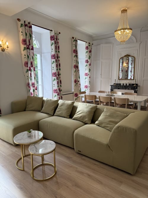 Elegant beige curved sofa with pillows in modern apartment at Les meublés d'Étigny, Bagnères-de-Luchon