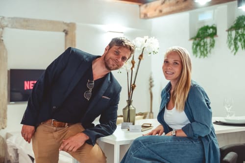 Due direttori di hotel sorridono nella moderna hall dell'hotel Verona con fiori bianchi e arredamento contemporaneo presso STAYIN VERONA