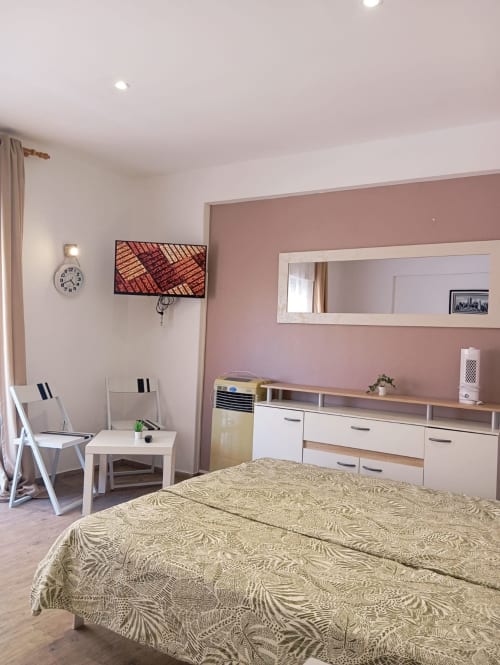 Quarto moderno no apartamento Sweet Home Casa dos Arcos, Portimão, com parede de destaque rosa, móveis brancos e padronizados