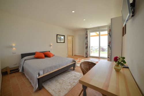 Spaziosa camera Superior con letto matrimoniale a Proprietà Clara ad Assisi, arredata modernamente, con accesso alla terrazza e illuminazione calda