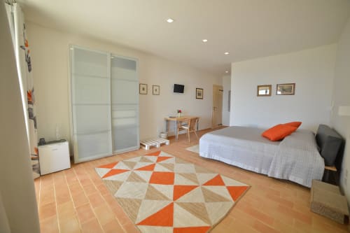Spaziosa camera Superior con letto matrimoniale, scrivania, tappeto geometrico e moderni comfort presso Proprietà Clara ad Assisi