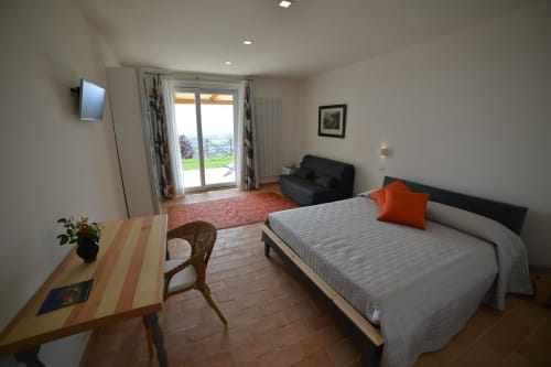Camera deluxe presso Proprietà Clara ad Assisi con letto, zona living, scrivania e vista dal balcone